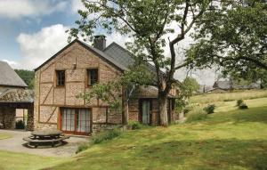 a brick house with a picnic table in front of it at La Maison D'albertine in Briscol