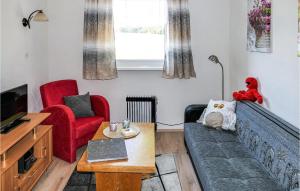 een woonkamer met een bank en een rode stoel bij Das Zechenhaus in Dankerode