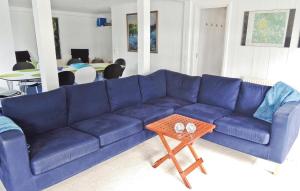 Sofá azul en la sala de estar con mesa en Gorgeous Home In Lammhult With House Sea View, en Asaryd