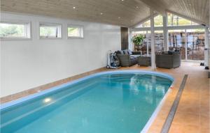 a swimming pool in a living room with a house at 4 Bedroom Awesome Home In Farsund in Herad