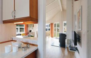 a kitchen with white cabinets and a tv in a room at Freibeuterweg 5 - Dorf 6 in Priwall +15 photos