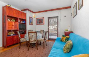 ein Wohnzimmer mit einem blauen Sofa und einem Tisch in der Unterkunft 3 Bedroom Lovely Home In Omisalj in Omišalj