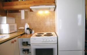 a kitchen with a white stove and a white refrigerator at Holiday Home Lyngdal Lindelia in Osestad +8 photos