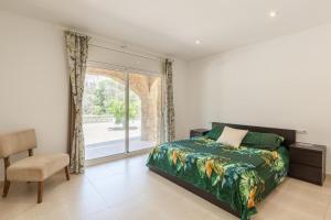 a bedroom with a bed and a window and a chair at Villallop in Olivella +20 photos