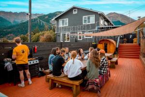 a group of people sitting at a table on a deck at The Black Sheep Backpackers in Queenstown