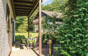 een patio met een tafel en stoelen en een heg bij Ferienhaus 19 In Thalfang in Thalfang