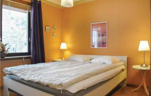 ビンメルビューにあるTwo-Bedroom Holiday Home In Vimmerbyのベッドルーム1室(黄色い壁の大型ベッド1台付)