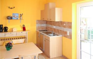 cocina con paredes amarillas, fregadero y mesa en Awesome Apartment In Fuhlendorf With Wifi, en Fuhlendorf