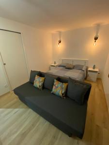 a bedroom with a bed and a couch with pillows at Studio Saint cyprien Plage in Saint-Cyprien +5 photos
