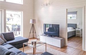 a living room with a couch and a television at Awesome Home In Kpingsvik With Kitchen in Köpingsvik