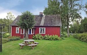una casa roja con una mesa de picnic delante de ella en 2 Bedroom Lovely Home In Knred en Timmerhult