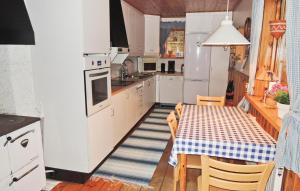 cocina con mesa y nevera blanca en 2 Bedroom Lovely Home In Knred en Timmerhult