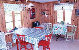 ein Esszimmer mit einem Tisch mit roten Stühlen, einem Tisch und einem Tisch in der Unterkunft Stunning Home In Storfors With 1 Bedrooms in Rådetorp