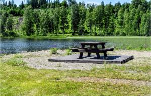 a picnic table sitting on a platform next to a lake at One-Bedroom Holiday Home In Austmarka in Östmarken +10 photos