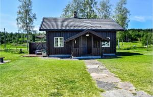 a small cabin in a field with a grass yard at 1 Bedroom Nice Home In Austmarka in Östmarken