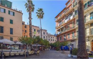 una calle con mesas, palmeras y edificios en 1 Bedroom Amazing Apartment In Sanremo im, en Villa San Secondo