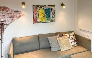 a couch in a living room with a painting on the wall at Gorgeous Home In Bunschoten-Spakenb in Bunschoten +16 photos