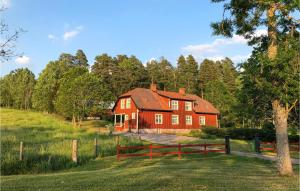 a red house in the middle of a field at Nice Home In Mantorp With Kitchen in Mantorp