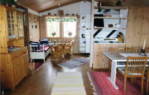 una cucina con armadi in legno, tavolo e sedie di Awesome Home In Nvekvarn With Kitchen a Nävekvarn