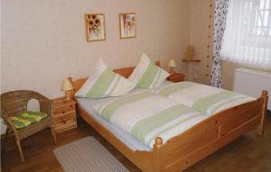 - une chambre avec un lit en bois et une chaise dans l'établissement Nice Apartment In Oberweser-gieselwerder With Wifi, à Gewissenruh