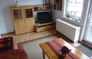 a living room with a television and a table at Stunning Apartment In Oberwesergieselwerder in Gewissenruh