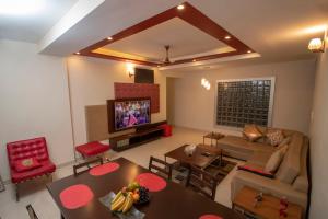 a living room with a couch and a table and a tv at Brook View Repose in Kolkata