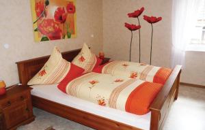 a bedroom with a bed with two pillows and flowers at Stunning Apartment In Oberwesergieselwerder in Gewissenruh