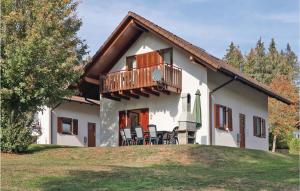 ein Haus mit einem Balkon und Stühlen auf einem Hof in der Unterkunft Ferienhaus 14 In Kirchheim in Kemmerode