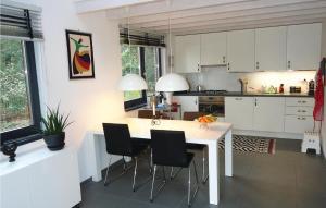 RekemにあるVijverdorp - Type Waterlelieの白いキャビネット、テーブルと椅子付きのキッチンが備わります。