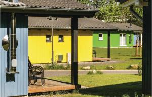 a yellow building with a wooden deck in a yard at Ferienhausdorf Thale in Thale