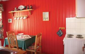 a kitchen with a table and a red wall at Holiday Home Ålvik Ytre Ålvik in Ytre Ålvik +9 photos