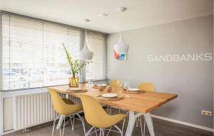 濱海貝亨的住宿－Sandbanks，一间带木桌和黄色椅子的用餐室