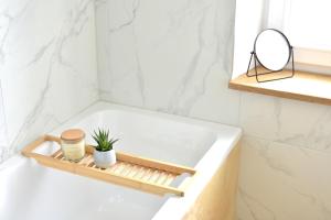 a bathroom with a bathtub with a plant on it at White Midsommar - Stilvolle Wohnung, 4 Schlafzimmer, Küche in Landshut +42 photos