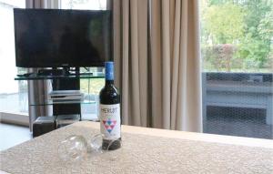 Una botella de vino sobre una mesa con una copa. en Oud Kempen Bungalow 183, en Stavenisse