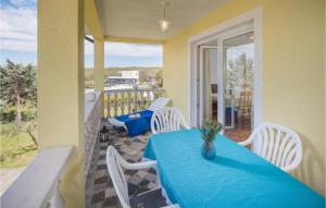 a table with a blue table cloth on a balcony at Amazing Apartment In Porec With 1 Bedrooms, Wifi And Outdoor Swimming Pool in Poreč