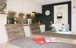 una cocina con armarios blancos y una mesa con un libro en Oud Kempen Bungalow 183, en Stavenisse