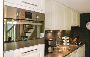 Una cocina con gabinetes blancos y un fregadero. en Oud Kempen Bungalow 183, en Stavenisse