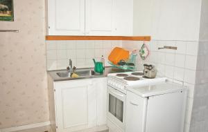 a small kitchen with a stove and a sink at Cozy Home In Strängnäs With Kitchen in Aspö