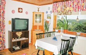 une salle à manger avec une table et une télévision dans l'établissement Cozy Home In Strngns With Kitchen, à Aspö