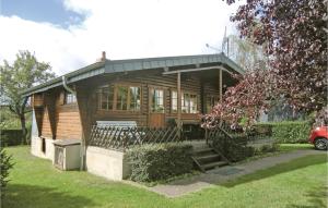 une maison en bois avec une terrasse couverte sur une pelouse dans l'établissement Mamet, à Waldbillig