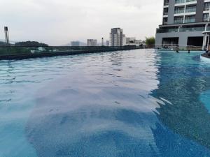 een groot zwembad met blauw water naast een gebouw bij Apple 5 @ Menara Simfoni/Symphony Tower Free Wifi/Parking/TV Box/Nexflix in Cheras