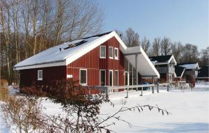 Un granero rojo con nieve en el suelo en Cozy Home In Rechlin With Wifi, en Rechlin