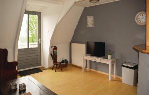 ein Wohnzimmer mit einem TV und einem Schreibtisch mit einem TV in der Unterkunft De Eekhof - Appartement 9 in Hindeloopen