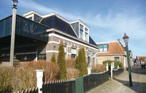 ein großes Haus mit einem Zaun und einer Straßenbeleuchtung in der Unterkunft De Eekhof - Appartement 9 in Hindeloopen