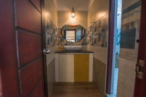 a bathroom with a sink and a mirror at mezzanine villa W/T Hot Tub Jacuzzi in Kālapettai +29 photos
