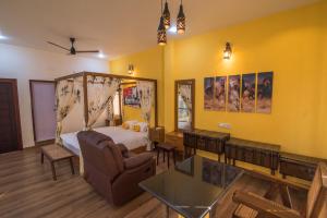 a room with a bedroom with a bed and a table at mezzanine villa W/T Hot Tub Jacuzzi in Kālapettai