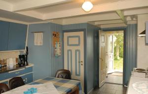 VanseにあるBeautiful Home In Vanse With Kitchenの青い壁のキッチン、テーブル、椅子付