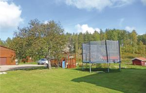 Nice Home In Malmkping With Kitchen في Malmköping: ملعب كرة سلة في ساحة مع منزل