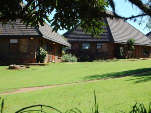 uma casa com um grande relvado em frente em Crystal Springs Mountain Lodge em Pilgrimʼs Rest