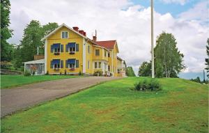 ein gelbes Haus auf einem Grashügel in der Unterkunft Awesome Home In Gräsmark With Sauna in Gräsmark